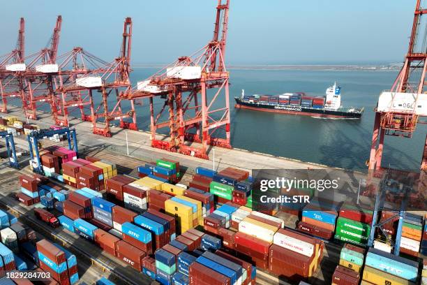 This photo taken on December 6, 2023 shows a cargo ship preparing to berth at the container terminal of Lianyungang Port in China's eastern Jiangsu...