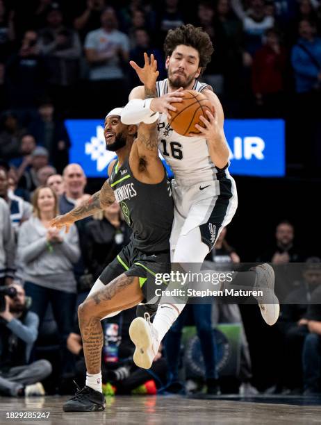 Cedi Osman of the San Antonio Spurs grabs the ball over Nickeil Alexander-Walker of the Minnesota Timberwolves in the first quarter of the game at...