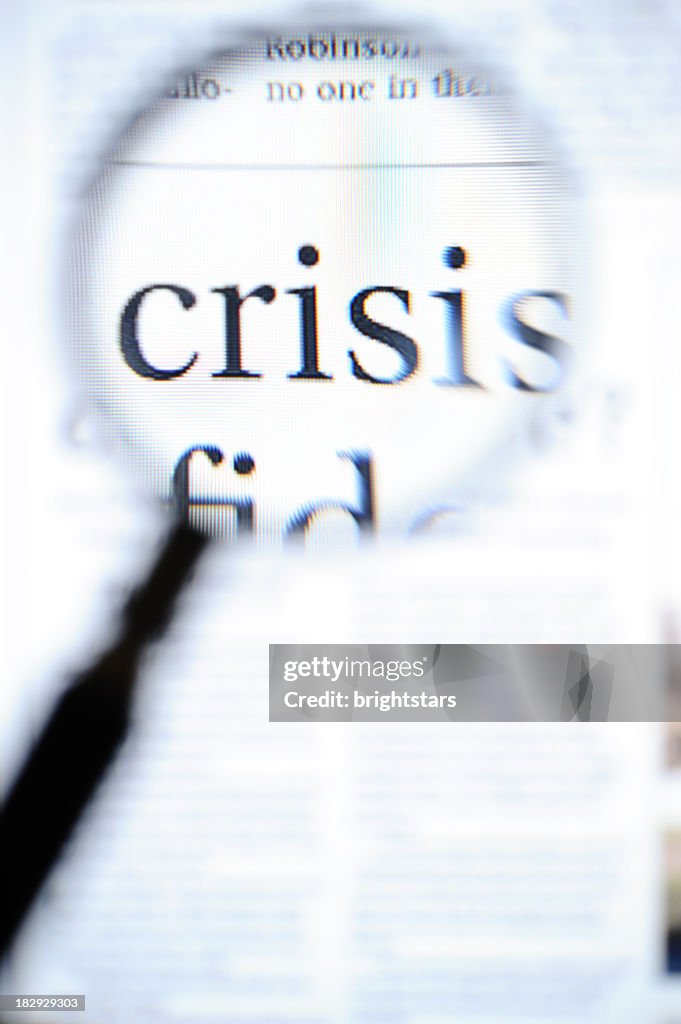 Magnifying glass focusing on crisis headlines