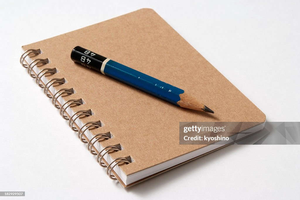 Isolated shot of spiral notebook with pencil on white background