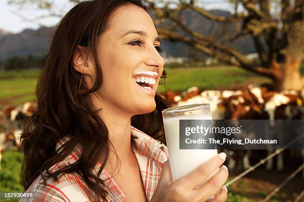 young woman drinking a glass of milk on a dairy farm - milk moustache stock pictures, royalty-free photos & images