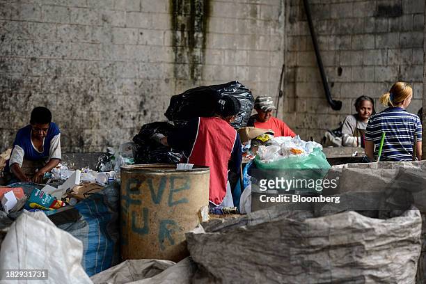 Workers separate trash for recycling at the COOPERVIVA garbage sorting facility in Rio Claro, Brazil , on Tuesday, Oct. 1, 2013. COOPERVIVA,...