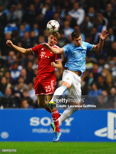 Thomas Mueller of Muenchen jumps for a header with Matija Nastasic of Manchester City during the UEFA Champions League Group D match between...