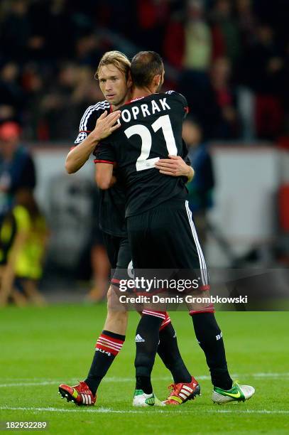 Simon Rolfes of Leverkusen is congratulated by teammate Omer Toprak after scoring the opening goal during the UEFA Champions League Group A match...