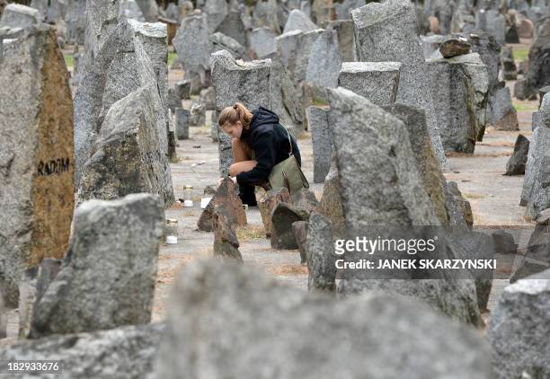 Polish girl scout lights a candle in front of the monument of Treblinka World War II-era Nazi death camp on October 2, 2013 in Treblinka. Around 600...