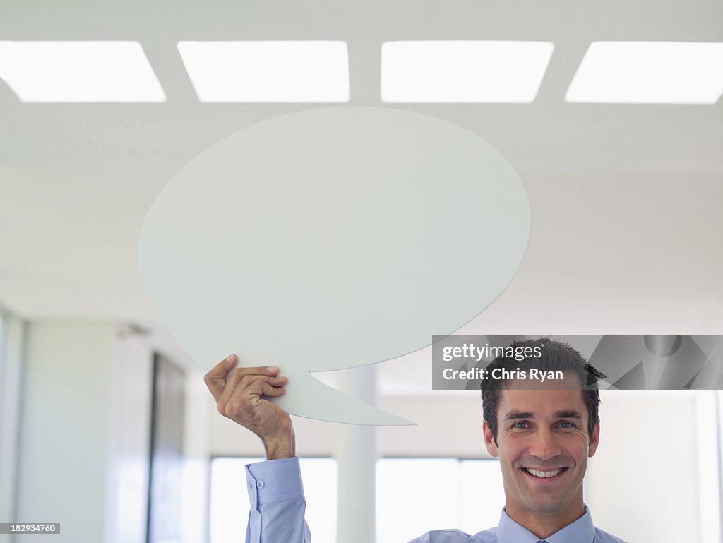 Businessman holding speech balloon