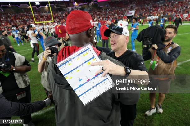 Head coach Todd Bowles of the Tampa Bay Buccaneers and interim head coach Chris Tabor of the Carolina Panthers meet on the field after their game at...