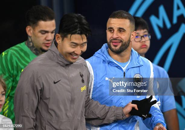 Son Heung-min of Tottenham Hotspur and Kyle Walker of Manchester City share a joke as they enter the field of play prior to the Premier League match...