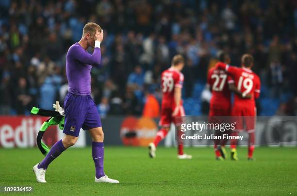 Goalkeeper Joe Hart of Manchester City holds his head as he walks off after the UEFA Champions League Group D match between Manchester City and FC...