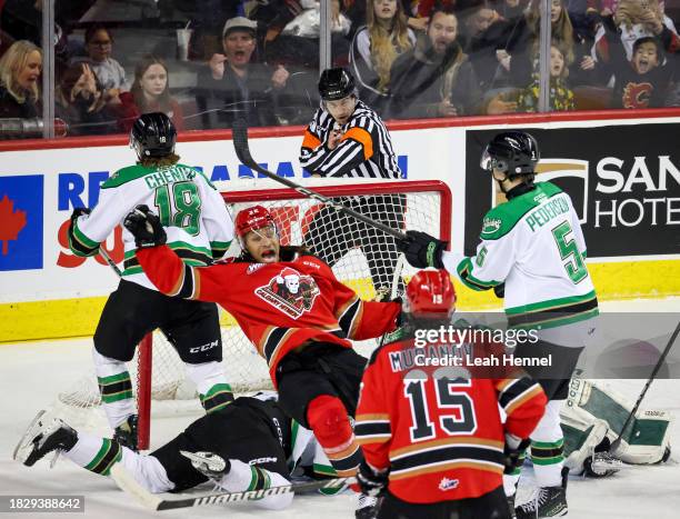 London Hoilett of the Calgary Hitmen trips into the net after after scoring a goal in the first period against the Prince Albert Raiders during the...