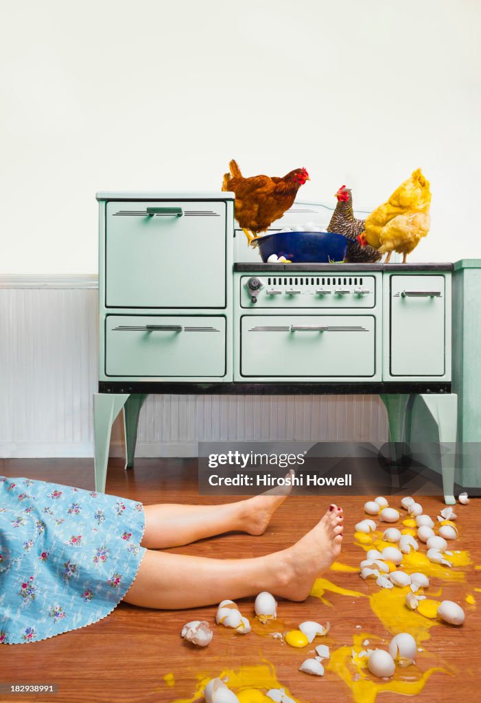 Caucasian woman on kitchen floor with broken eggs