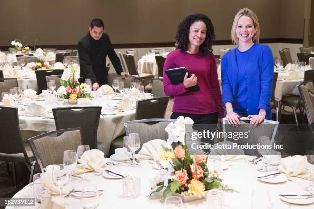 businesswomen smiling in dining room - organizador de eventos fotografías e imágenes de stock