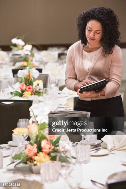 african american businesswoman working in dining room - organizador de eventos fotografías e imágenes de stock