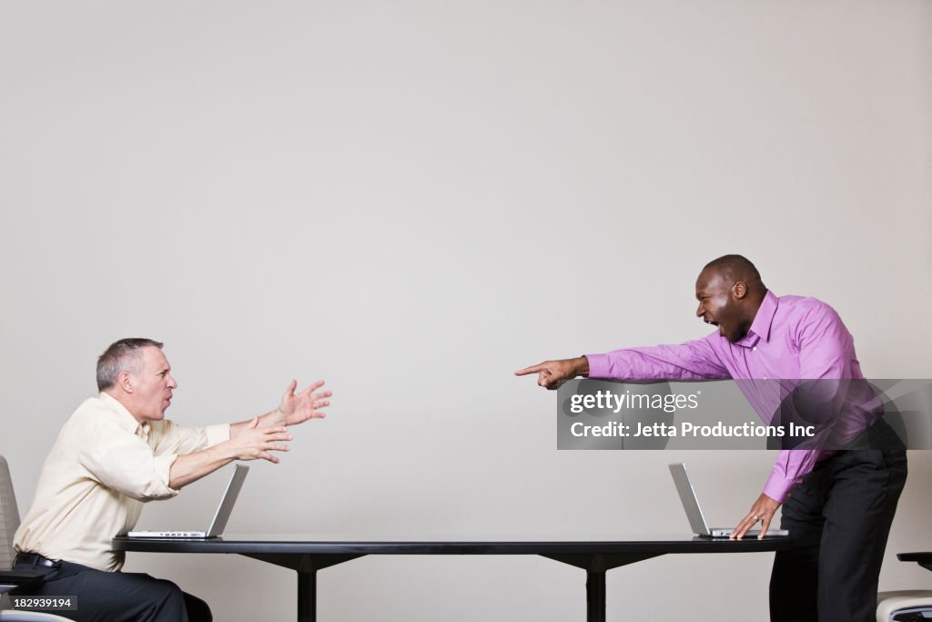 Businessmen shouting across table