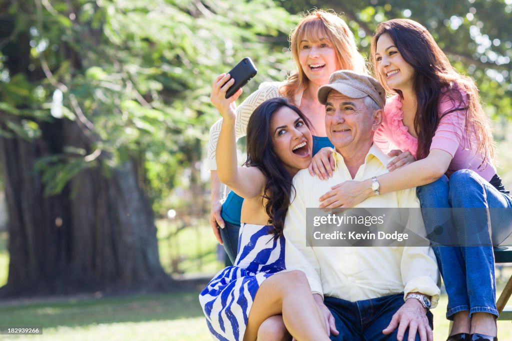 Hispanic family taking pictures together outdoors