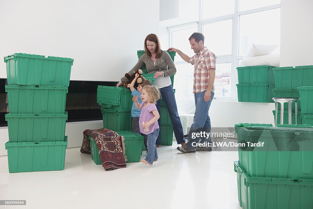 Caucasian family playing in new home
