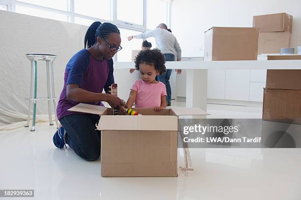 black mother and daughter unpacking in new home - open day 5 stock pictures, royalty-free photos & images