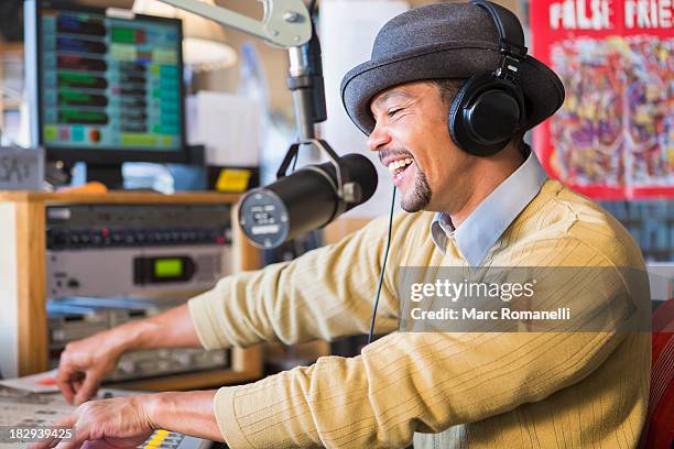 mixed race disc jockey using turntable in studio - radio jockey stock pictures, royalty-free photos & images