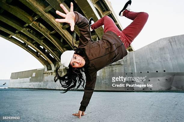 hispanic woman break dancing under overpass - a la moda stock pictures, royalty-free photos & images