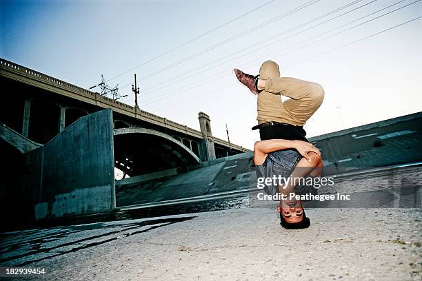 mixed race man break dancing under overpass - break dancer stock pictures, royalty-free photos & images