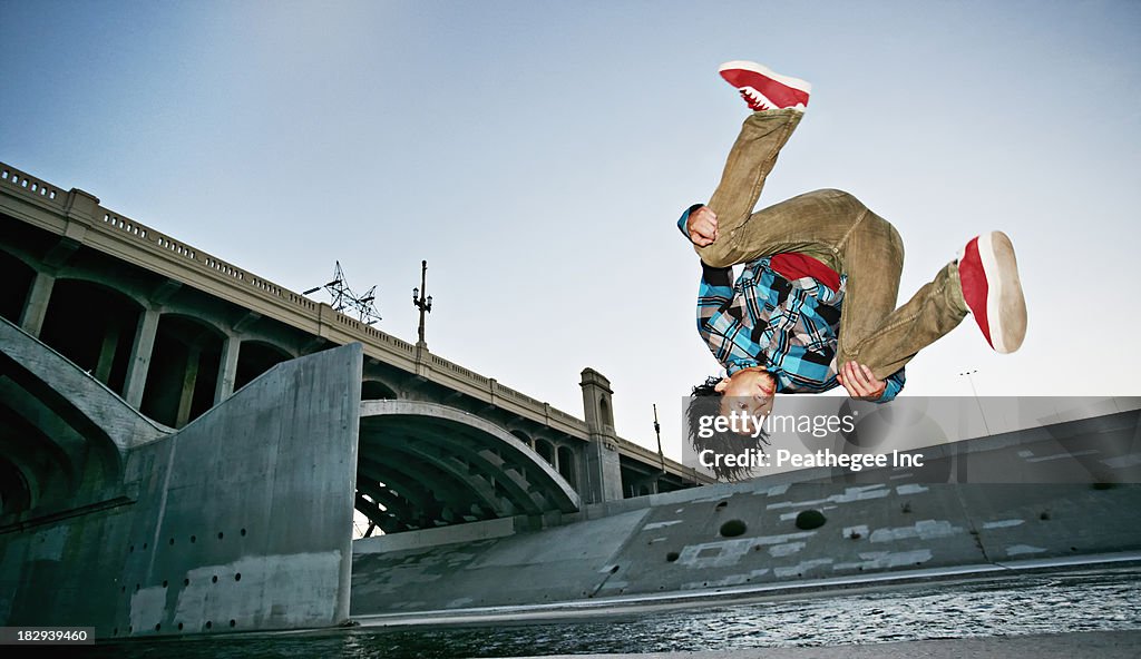 Asian man break dancing under overpass