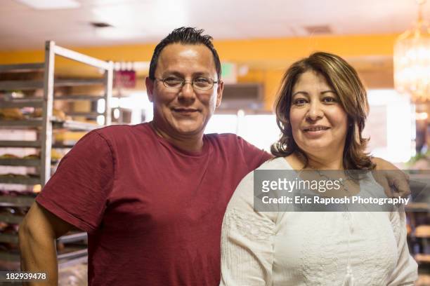 hispanic bakers smiling in kitchen - business mature couple portrait bildbanksfoton och bilder