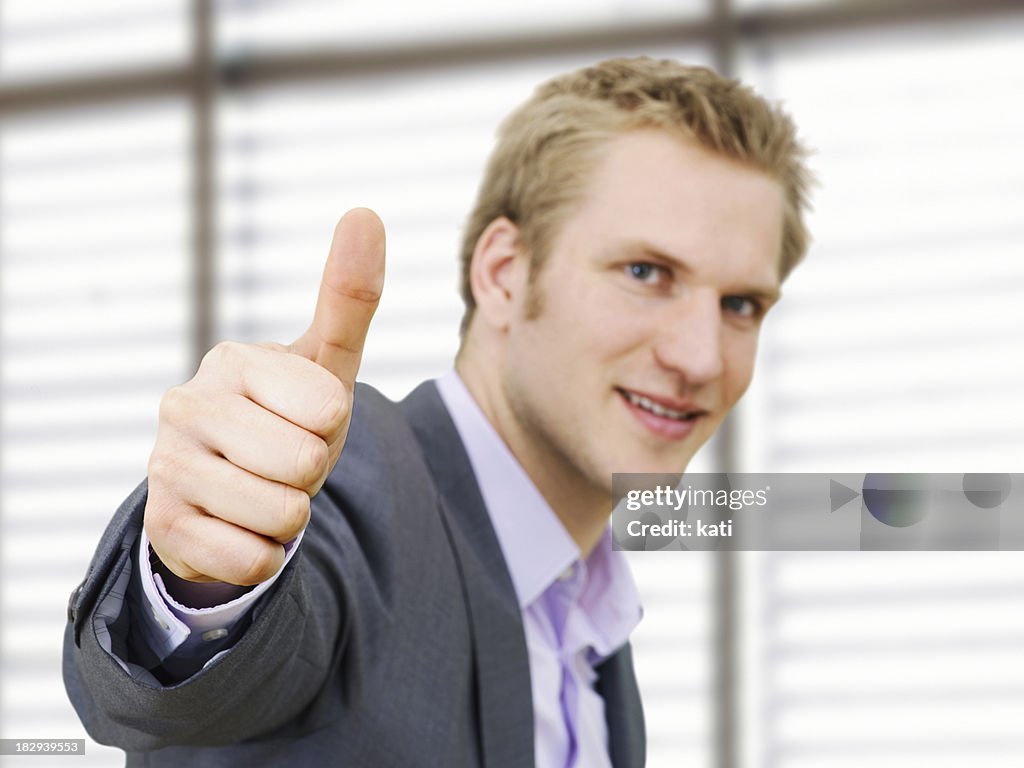 Businessman making a thumbs-up gesture