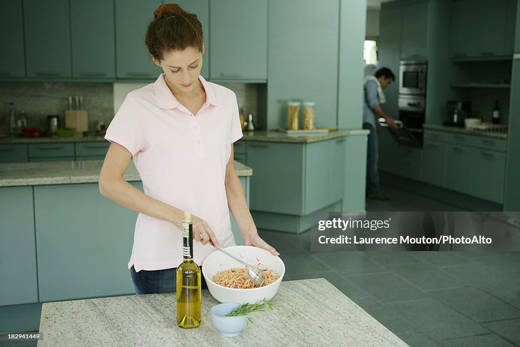 Young woman preparing spaghetti