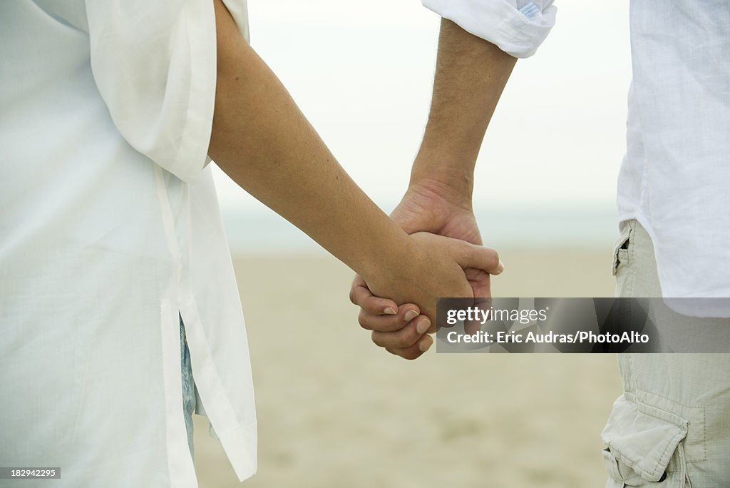 Couple holding hands, cropped