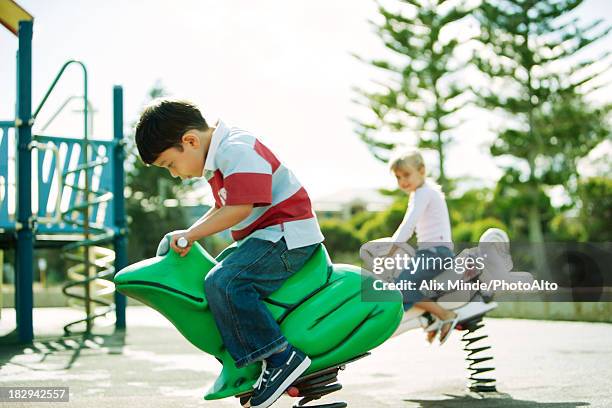 boy riding on frog at playground - boy frog stock pictures, royalty-free photos & images