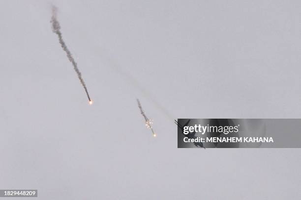 Picture taken in southern Israel near the border with the Gaza Strip on December 7 shows an Israeli fighter jet dropping flares over Gaza, amid...