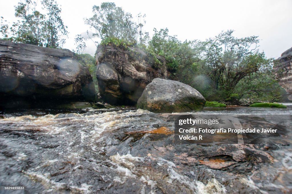 Sailing on the Caruao River, via Angel Falls. Walk through the teyues, large stone mountains from the Jurassic period.
