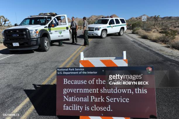 Park Rangers stand at the closed gate to Joshua Tree National Park, in Joshua Tree, California on October 2 the second day of the US government...