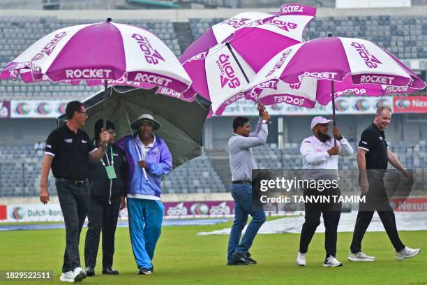 Umpires and officials inspect the field as rain washed out the second day of play during the second Test cricket match between Bangladesh and New...