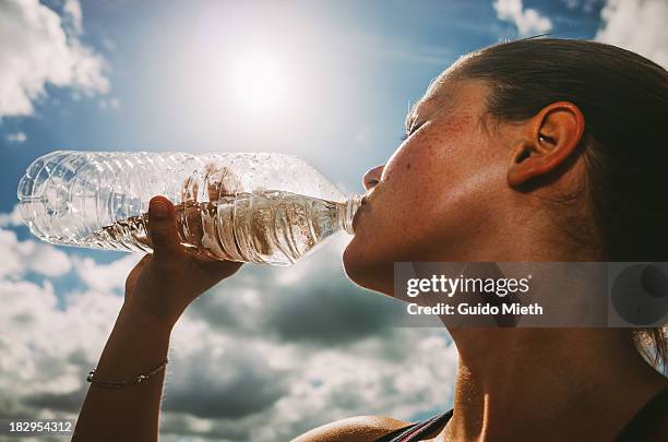 woman drinking water in bright sun light - drink water fotografías e imágenes de stock