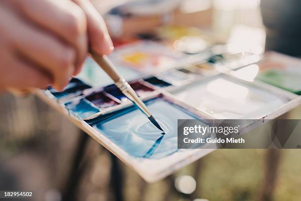 colour mixing on a watercolour pallette - farbpalette stock-fotos und bilder