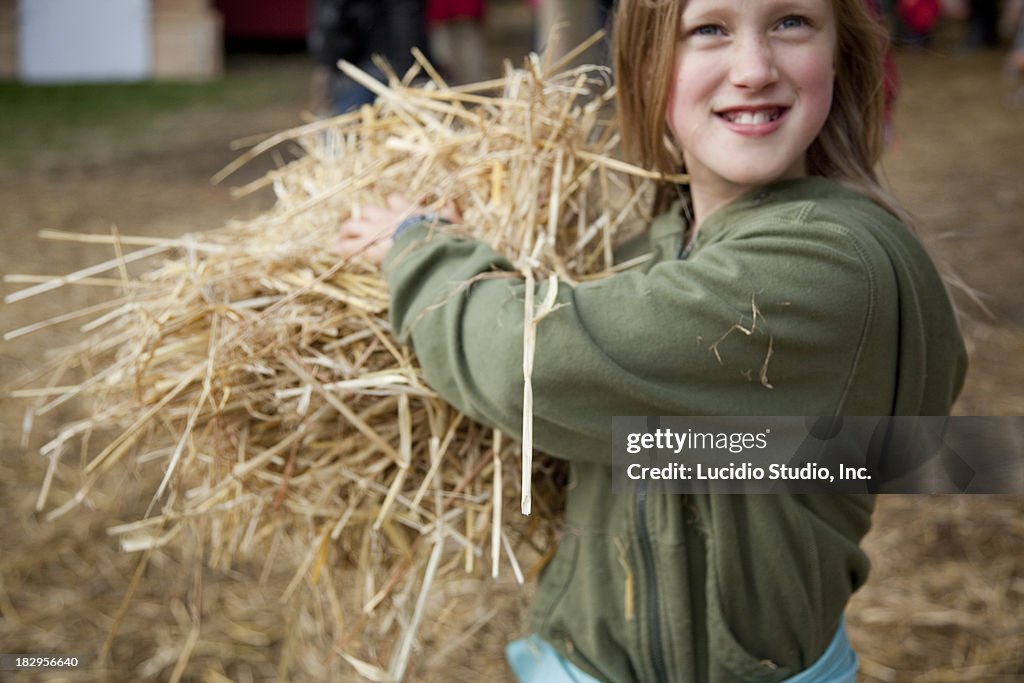 Girl throwing around hay