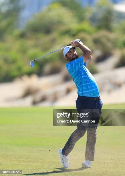 This image is part of a swing sequence; Scottie Scheffler of The United States hits a six iron for his second shot on the third hole during the final...