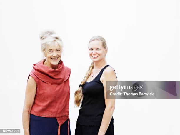 two smiling mature women against white background - side by side stock pictures, royalty-free photos & images