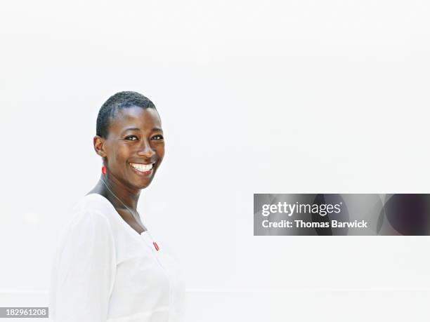 smiling woman standing against white background - black woman happy white background foto e immagini stock