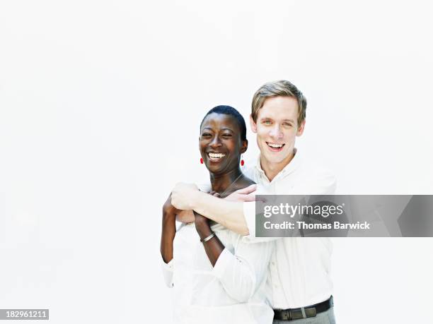 Smiling couple embracing against white background