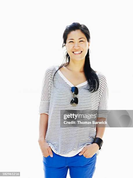 smiling woman standing with hands in pockets - 2013newwomen stock pictures, royalty-free photos & images