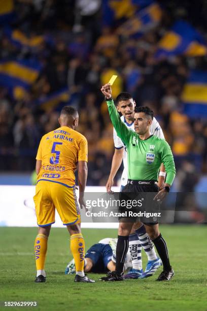 Referee Adonai Escobedo shows a yellow card to Rafael De Souza of Tigres during the quarterfinals second leg match between Tigres UANL and Puebla as...