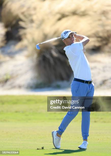 This image is part of a swing sequence; Justin Thomas of The United States hits a seven iron for his second shot on the third hole during the final...