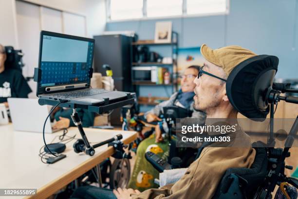 pessoas com habilidades variadas trabalhando juntas em um pequeno escritório - esclerose lateral amiotrófica - fotografias e filmes do acervo