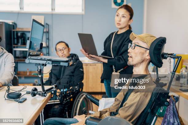 des personnes aux capacités variées travaillant ensemble dans un petit bureau - accessibilité aux personnes handicapées photos et images de collection