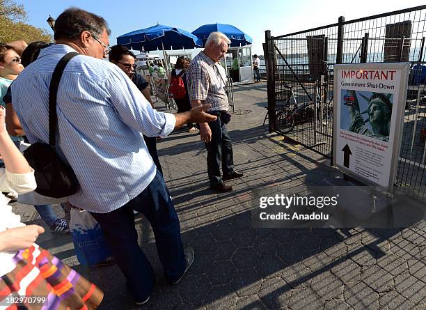 October 2 : People read a sign announcing the closure of Statue of Liberty and Ellis Island due to the government shutdown on 2 October 2013 in New...