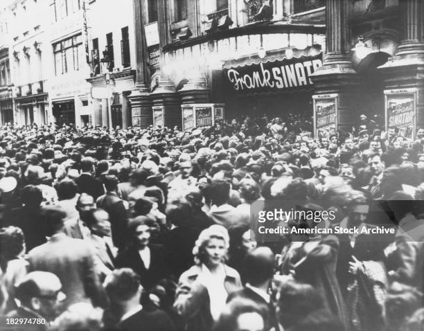 Crowds outside the London Palladium theatre, which is advertising an appearance by American actor and singer Frank Sinatra, circa 1950.