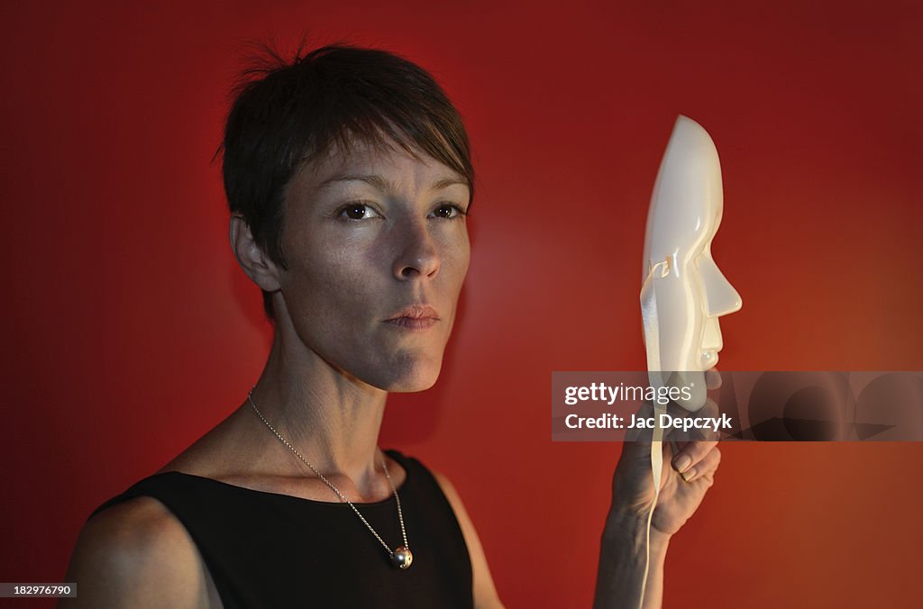 Young woman holding white plastic mask