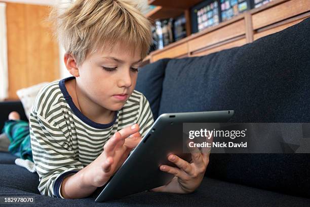 child playing on tablet - children on a tablet stock pictures, royalty-free photos & images